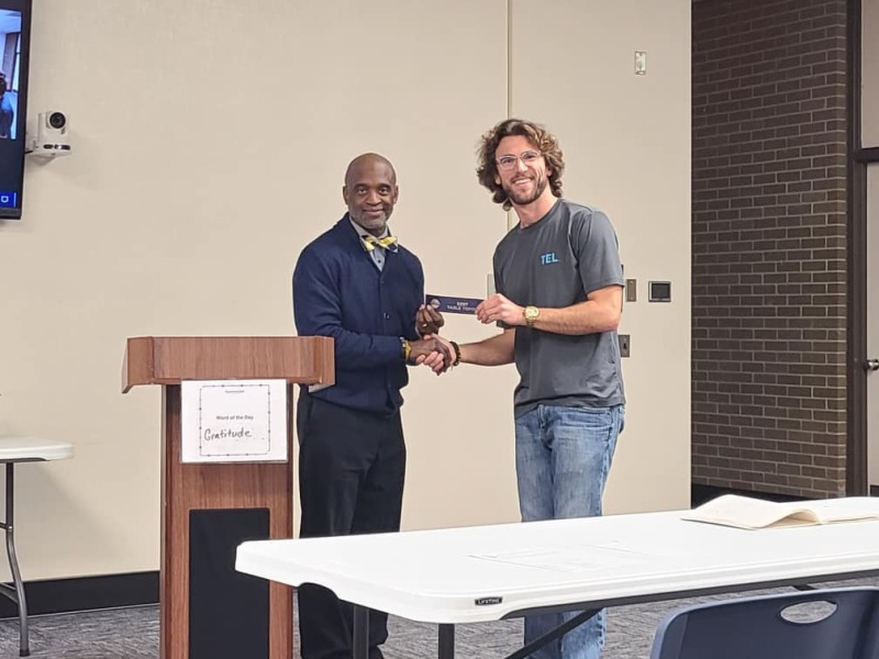 Toastmaster Dennis Szymanski receiving an award ribbon from Jacksonville Toastmaster club president